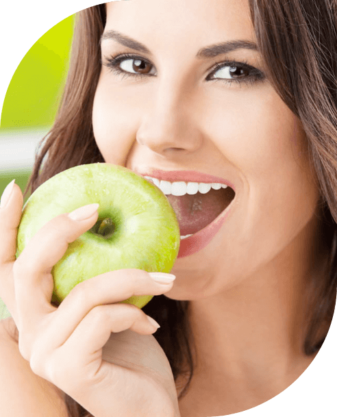Woman eating an apple after a holistic dentistry visit