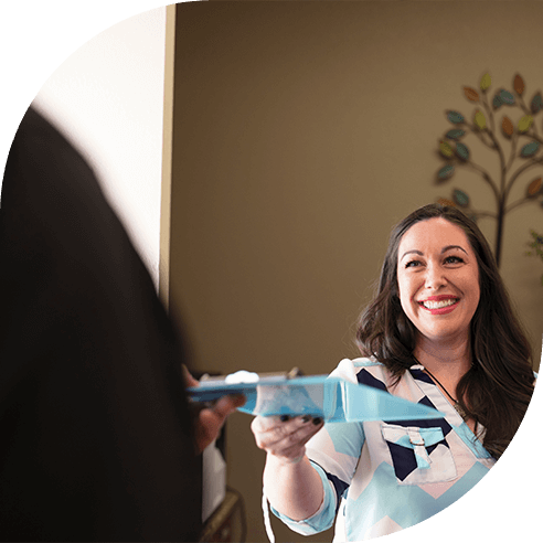 Friendly dental team member handing dental patient a clipboard