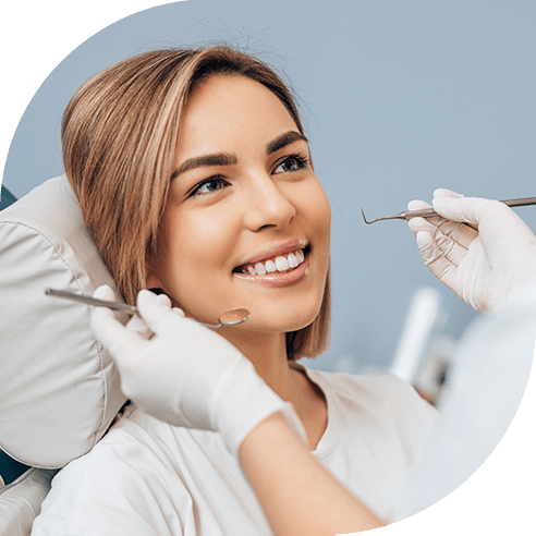 A young woman getting teeth checked by a dentist