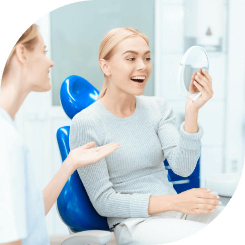 Woman looking at smile after porcelain veneer placement