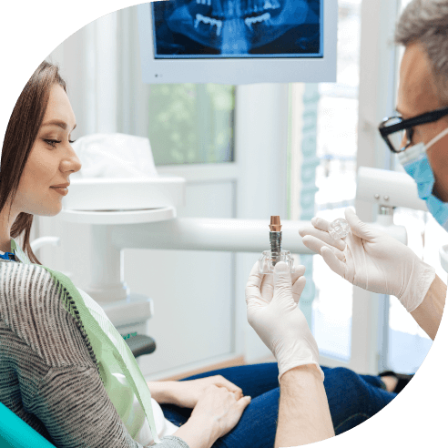 Dentist and patient discussing the four step dental implant process