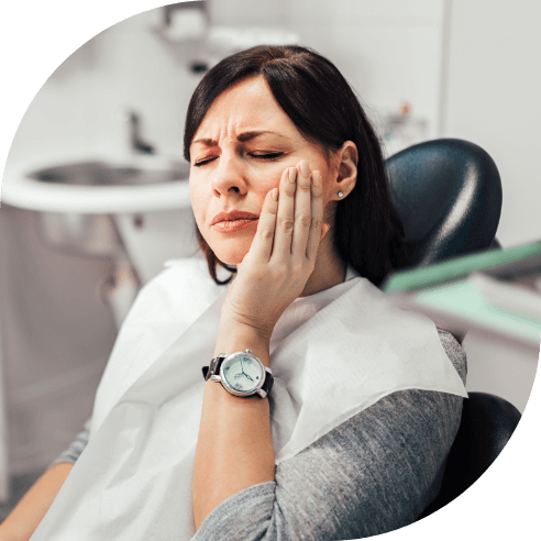 Woman holding cheek before emergency dentistry treatment