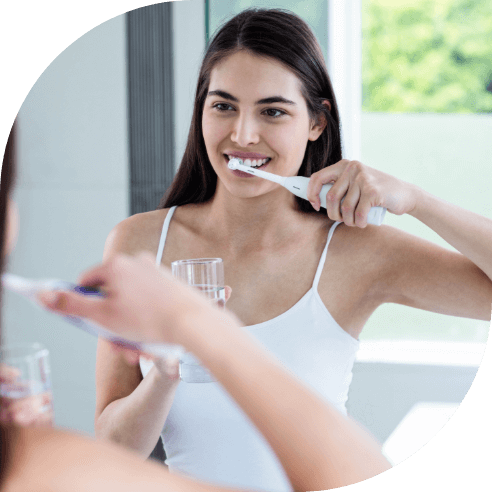 Woman brushing teeth to prevent dental emergencies