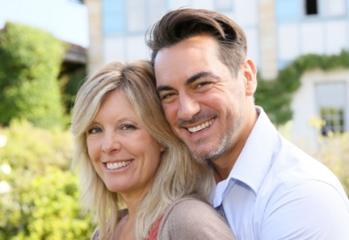 Happy man and woman holding each other outdoors