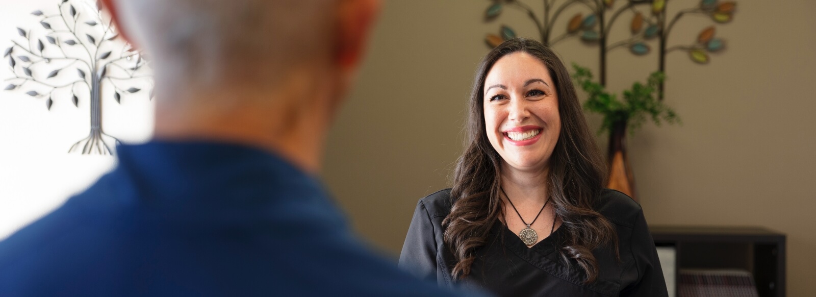 Friendly holistic dental team member smiling at dental patient