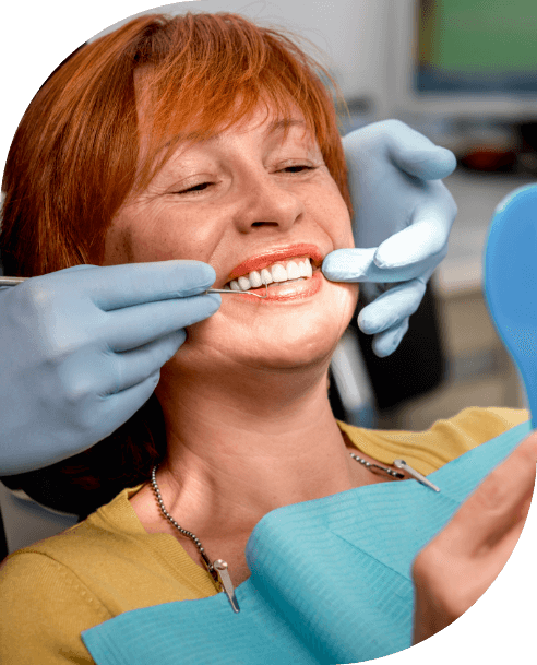 Woman looking at smile during restorative dentistry visit