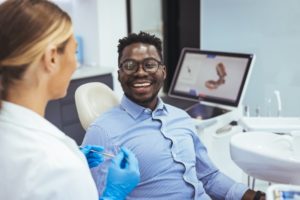 a man is getting his loose tooth treated at the dentist