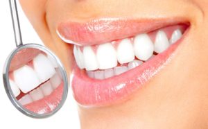 Close-up of woman’s smile and dental mirror