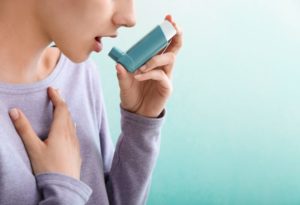 Woman preparing to use her asthma inhaler