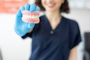 Dental lab tech holding dentures
